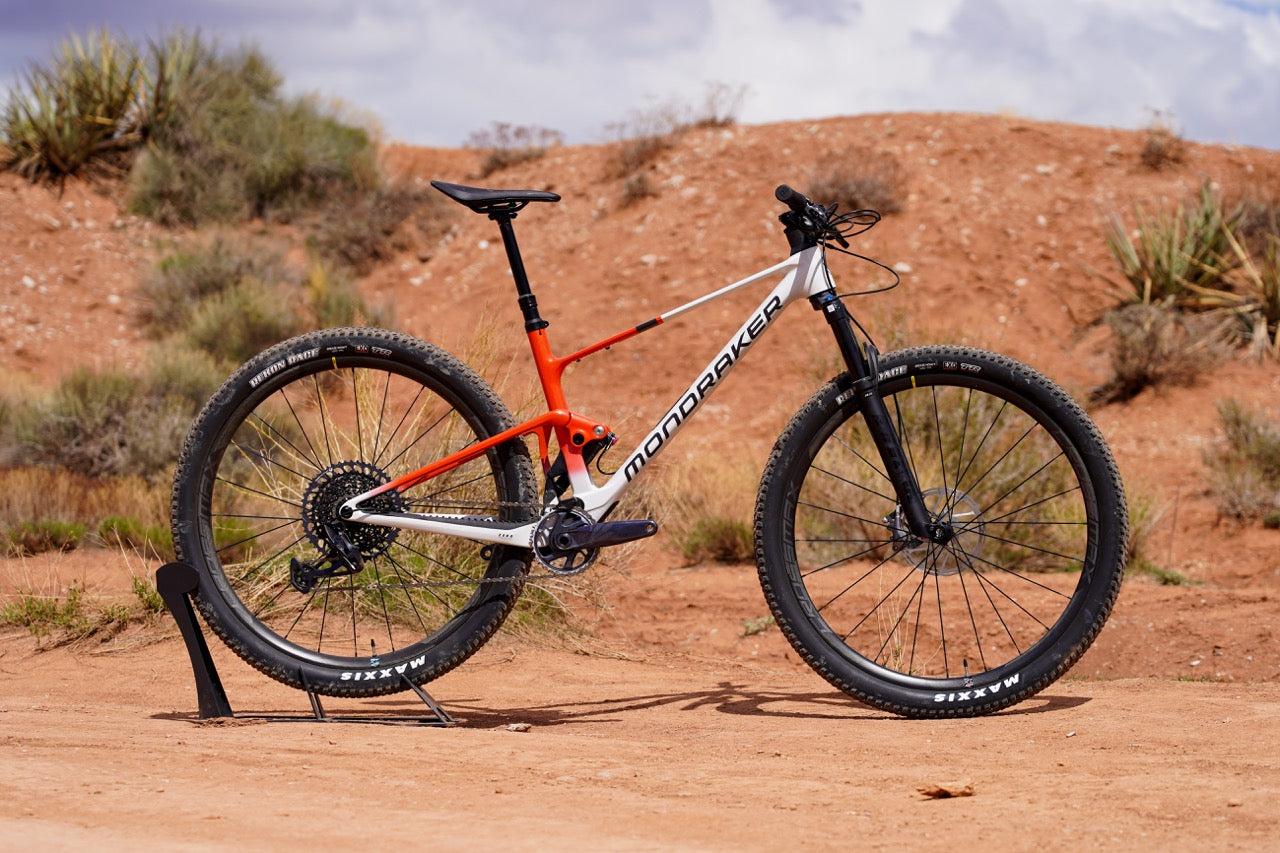 a silver and red mondraker mountain bike with flat handlebars and black lettering