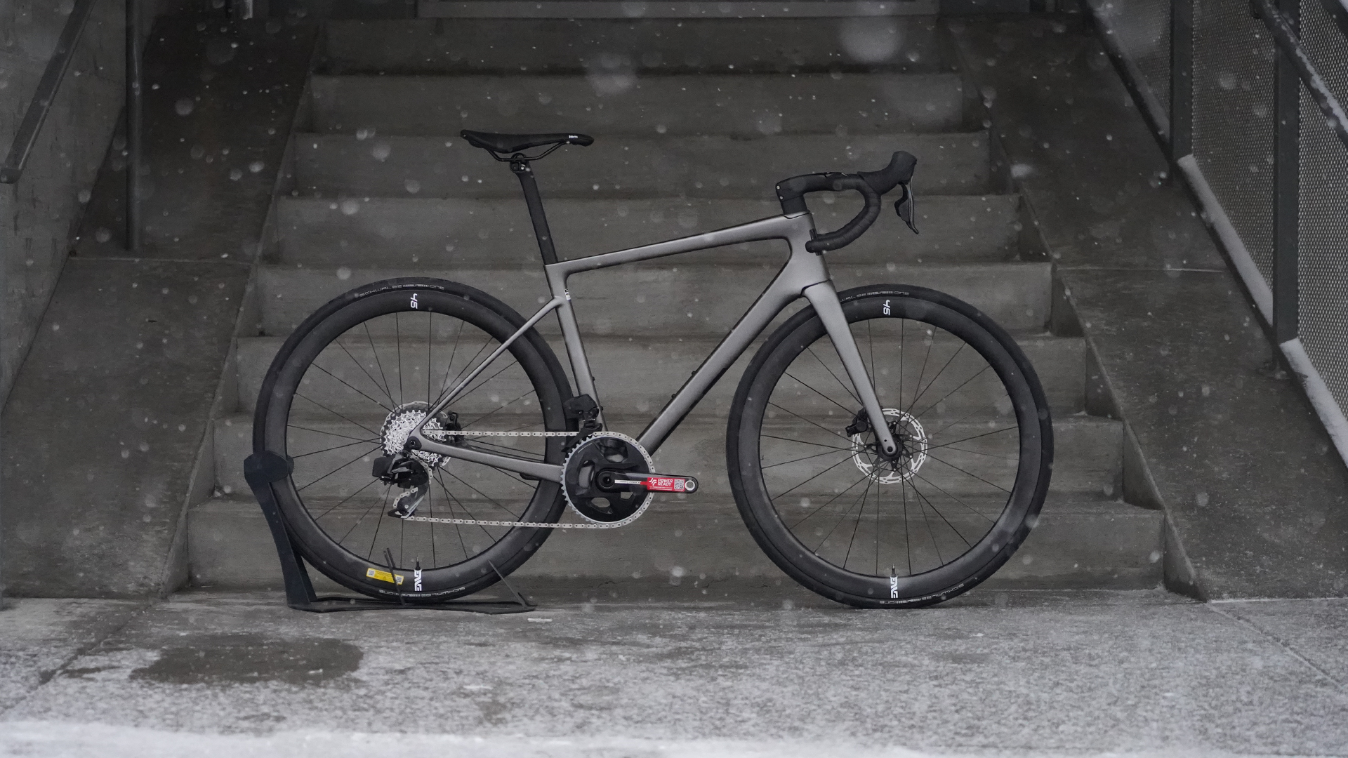 a silver enve mog gravel bike with drop handlebars and snow falling in the background