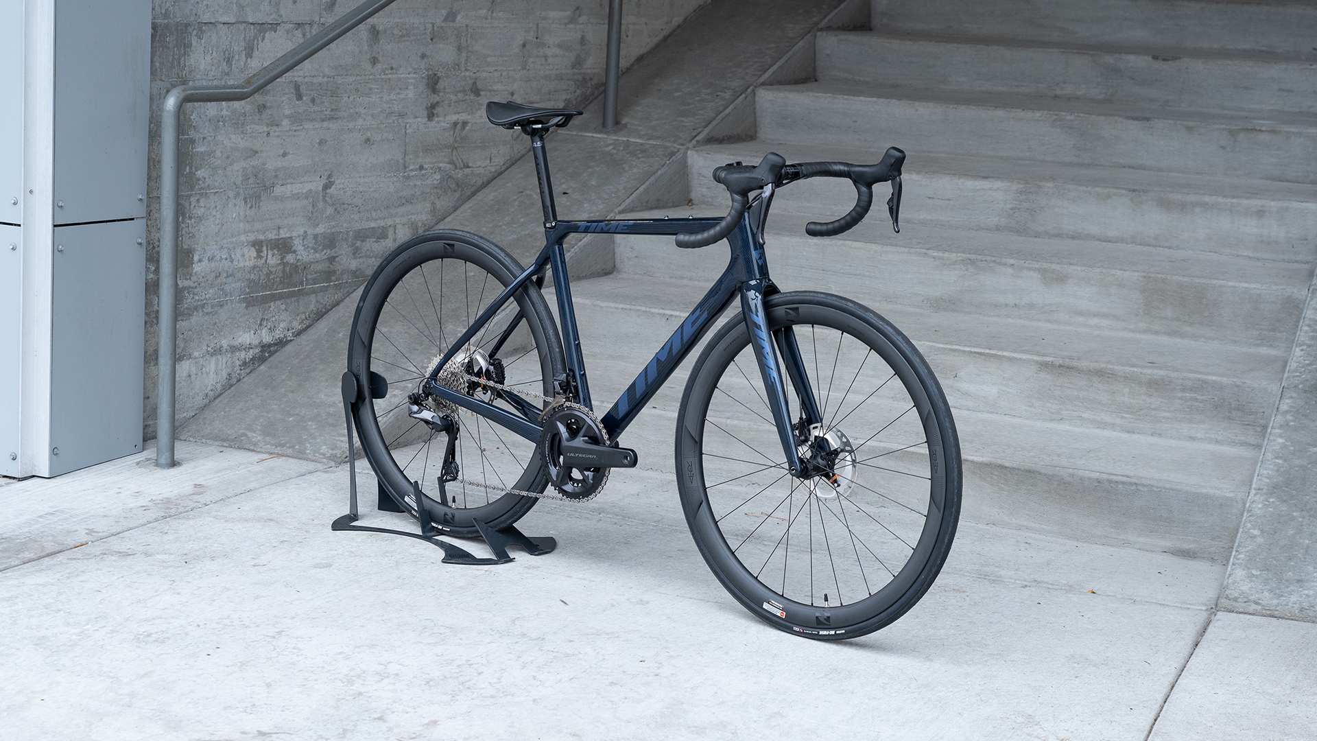 a dark blue time gravel bike with lighter blue lettering and drop handlebars