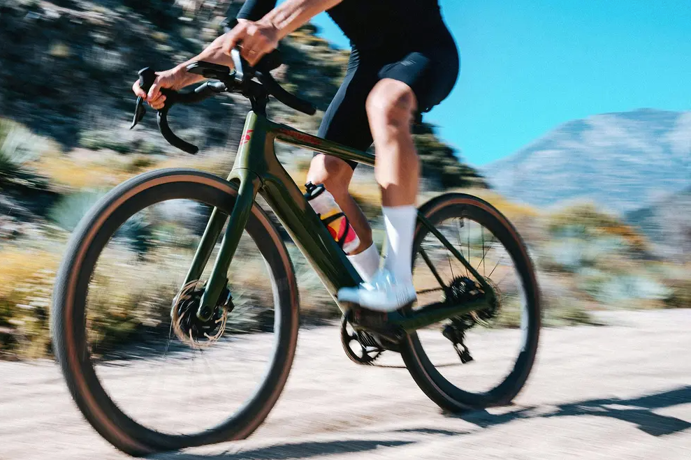 a cyclist riding a cervelo rouvida electric bicycle on a gravel path 