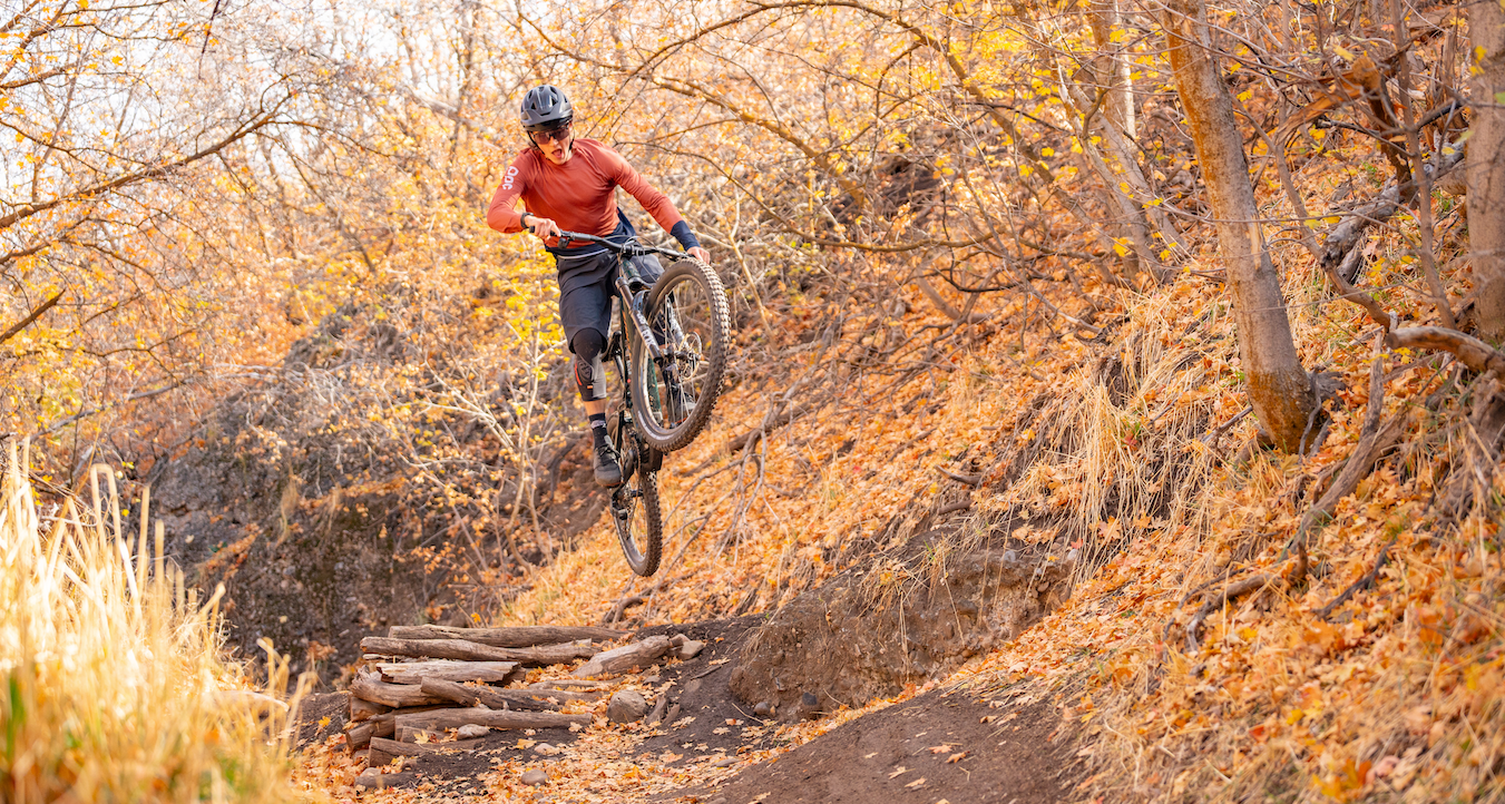 a man riding a santa cruz vala electric bicycle on a dirt path with leaves